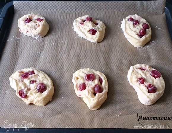 Свернуть тесто по короткой стороне в рулет и разрезать на 12 частей. Выложить плюшки на 2 противня, покрытых бумагой для запекания. 