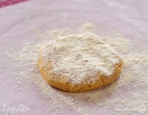 Присыпать хорошенько рабочую поверхность мукой,положить посерединке лепешечку,ее тоже присыпать мукой