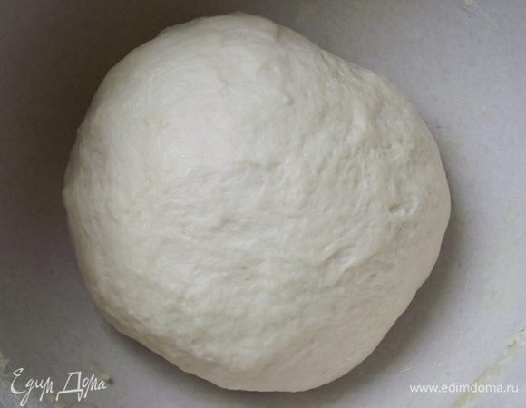 Дрожжи присыпать щепоткой сахара и оставить на 10 минут для «пробуждения». К воде добавьте соль, сахар, оливковое масло и доведите до кипения. Снимите с огня и остудите до комнатной температуры. Добавьте дрожжи и перемешайте венчиком. Затем постепенно добавьте просеянную муку и замесите эластичное тесто. Руки смажьте оливковым маслом — это поможет равномерно замесить тесто. Добавление в тесто оливкового масла – один из главных секретов хорошей пиццы. Тесто становится гладким, эластичным. Смажьте миску маслом и отправьте тесто подходить на 1 час в теплое место, накрыв его влажным полотенцем.