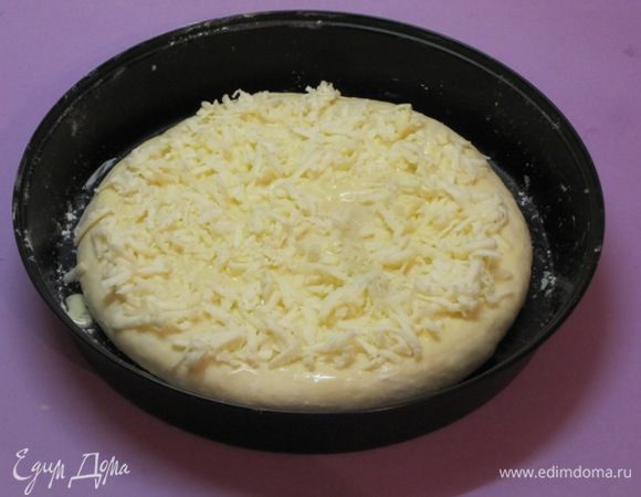 Намазать получившейся смесью хачапури. Оставшиеся 50 грамм тертого сыра распределить сверху.