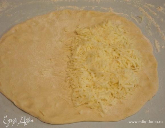 На одну часть получившегося круга выложить тертый сыр сулугуни.