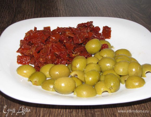 Пока язык остывает, нарезать вяленые томаты, предварительно слив масло. Оливки разрезать пополам.