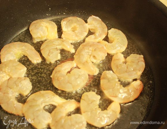 На сковороде разогрейте оливковое масло. Обжарьте в нем креветки с обеих сторон. 