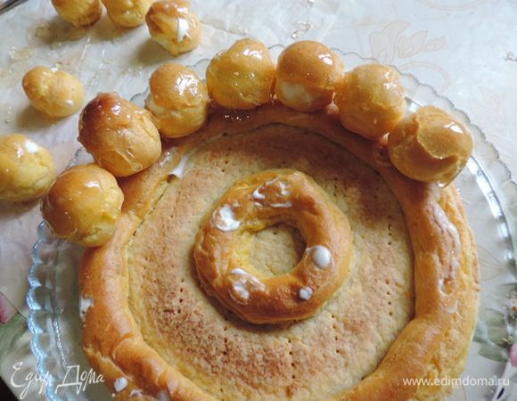 Верхушки наших пироженок обмакиваем в горячую карамель. Затем в карамель окунаем их донышки, можно чайной ложечкой слегка смазывать дно пирожных карамелью и приклеиваем их к внешнему кольцу на корже-основе. 