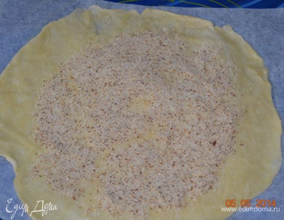 2 ст.л. миндальной муки смешать с 2 ст.л. сахара и посыпать на середину теста, (оно должно быть прохладным, если вы не успели с начинкой, то раскатанный уже на пергаменте и уложенный на противне круг теста, нужно отправить в холодильник) отступая по 2 см.от края теста.