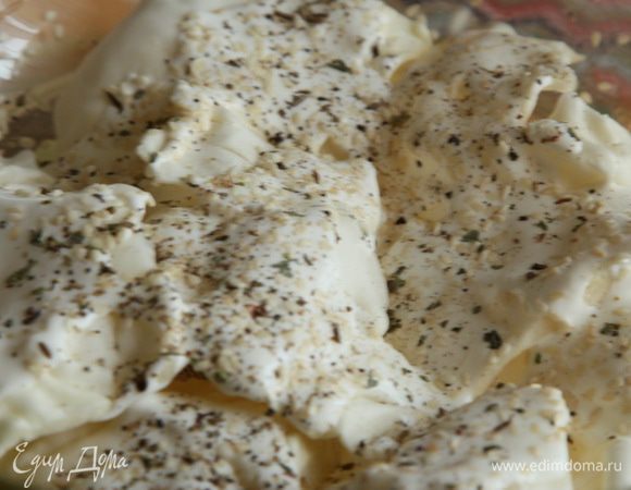 Смазываем сметаной, посыпаем тмином, кунжутом, базиликом и перцем молотым.