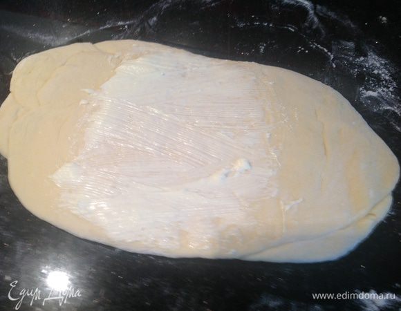 Раскатать прямоугольный пласт, середину смазать 1/8 частью размягченного сливочного масла.