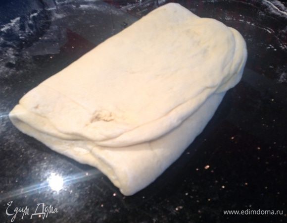 Левым концом пласта накрыть намазанную среднюю часть и сверху смазать маслом образовавшийся второй слой. После этого накрыть этот слой свободным правым концом пласта. Получается закатка, состоящая из трех слоев теста и двух слоев масла. 