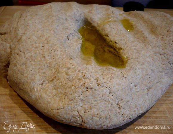 На припыленной мукой поверхности еще раз хорошо вымесим поднявшееся тесто. Сделаем углубление по середине и добавим 1 ст.л. оливкового масла. Вмассируем ее в тесто и повторим эту процедуру еще трижды, пока все 4 ст.л. масла не окажутся в тесте. 