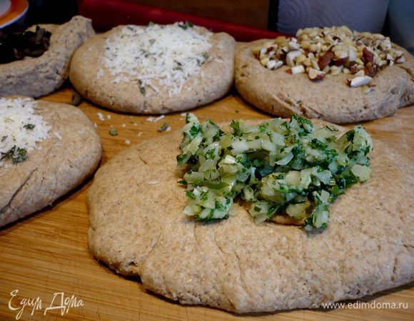 Раскатаем тесто в батон и разделим на 4 равные части. Каждую часть перемешаем с определенной начинкой. Сначала скатаем тесто в шар, прижмем ладошкой, чтобы образовалась лепешка, и выложим в центр начинку, соединим края. 