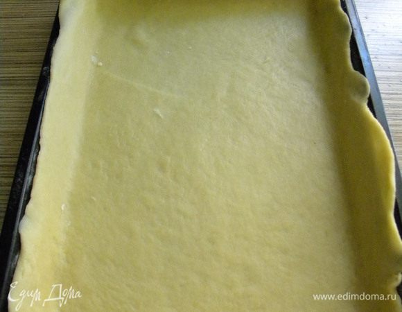 Делим тесто на 2 части, одну часть раскатываем в форму.