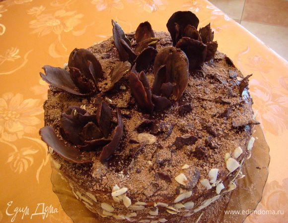 Украшаем торт: бока миндальными лепестками, сверху насадить цветы и сверху посыпать тертым, оставшимся шоколадом.