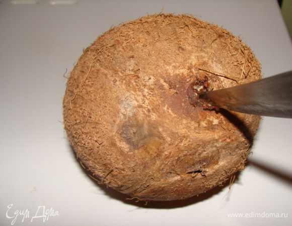 Кокосовое молоко можно купить готовое. Но я готовила в домашних условиях из свежего кокоса, что гораздо лучше.
Для этого в орехе выбираем точку, которую легко можно расковырять ножом (две других не поддаются вскрытию), когда услышим своеобразный шипящий звук, значит все делаем правильно. Расширяем отверстие ножом и сливаем прозрачную жидкость. 