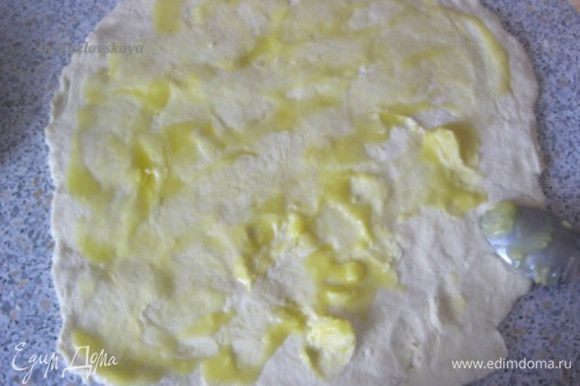 Раскатать тесто на присыпанной мукой поверхности. Смазать оставшимся растопленным маслом.