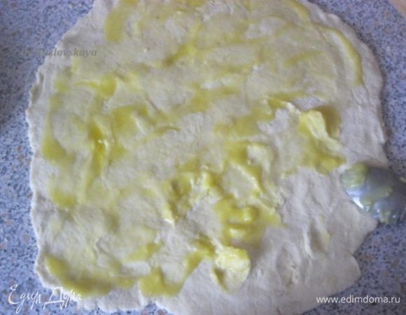 Раскатать тесто на присыпанной мукой поверхности.
Смазать оставшимся растопленным маслом.