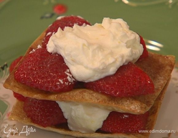 На остывший лист теста выложить немного клубники, смазать кремом, накрыть вторым листом теста, снова выложить ягоды, смазать кремом и накрыть еще один листом. Сверху украсить ягодами.