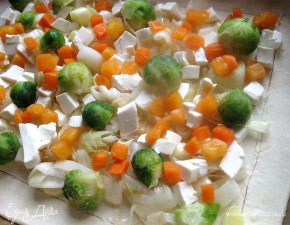 Далее -  кочанчики брюссельской капусты, разрезанные пополам. Кусочки свежезамороженной тыквы разморозить, дать оттаять и отжать. Положить на тесто.