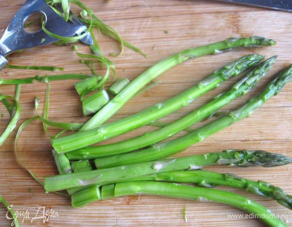 Зачистить немного стебельки спаржи овощечисткой.  Спаржу припустить        ( подержать 2 минуты в кипятке, затем положить на салфетку, чтобы убрать лишнюю воду), можно этого не делать, тогда она будет после выпечки чуть жестковатой. 