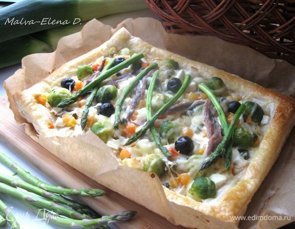 Духовку разогреть до 200 градусов. Поставить форму в духовку в общей сложности  на  35 – 40 минут. Запекать до румяной корочки теста.  Через 20 - 25 минут после начала выпечки  вынуть, помазать бортики желтком, смешанным с водой. Отправить снова в духовку. За несколько минут до конца выпечки положить спаржу.  