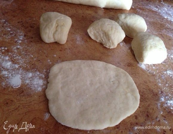 Скатать две "колбаски'"и нарезать примерно на 10-12 частей. Взять одну часть и раскатать в небольшую лепешку.