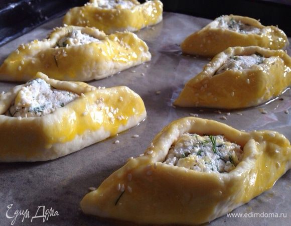 В желток (который мы оставили) добавить 2 ст. л. растительного масла и слегка взбить вилкой. Сложить пирожки на противень, смазать желтком и посыпать кунжутом.