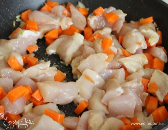 К луку добавить нарезанную кубиками морковь и нарезанное на небольшие кусочки куриное филе. Готовить, помешивая, около 10 мин (ориентируйтесь на готовность курицы).