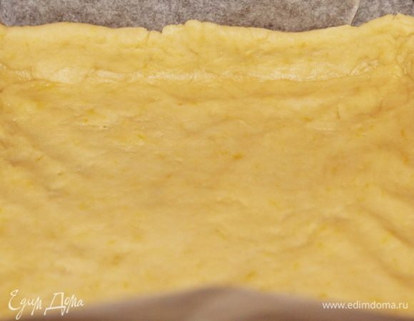 Затем, постепенно добавляя воду, скатать тесто в мягкий эластичный шар. Раскатать тесто и выложить в противень, выстеленный пергаментом. Растянуть тесто по форме, сделав бортики, у меня приблизительно 2 см. Противень размером 20х20х5 см.