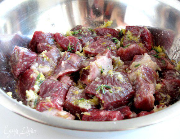 Мясо сложить в миску, добавить листики тимьяна, лимонный сок, лимонную цедру, измельченный чеснок и растительное масло. Посолить и поперчить. Хорошо перемешать и оставить мариноваться на 1 час.