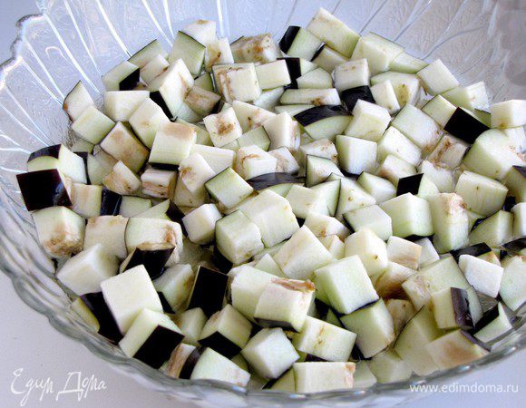 Баклажан нарезать кубиками, сложить в миску, залить холодной, слегка подсоленной водой и оставить на 20 минут.