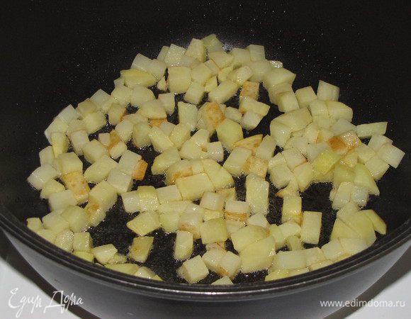 В глубокой кастрюле с толстым дном или высокой сковороде разогреть растительное масло и обжарить картофель, нарезанный кубиком, 5 минут.