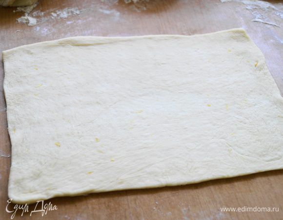Готовое тесто разделить на 2-3 части, чтобы было удобнее раскатывать. Взять одну часть и раскатать в тонкий пласт.