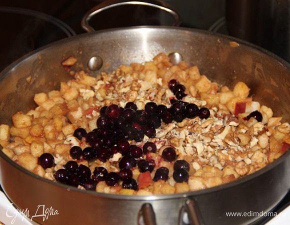 Пока выпекается основа, разогрейте оставшееся сливочное масло в большой сковороде до появления пены. Помешивая, обжарьте в нем яблоки с корицей в течение 3 минут до небольшой мягкости. Снимите с огня, добавьте, помешивая, ягоду и рубленые орехи. 