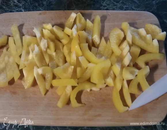 Перец нарезаем небольшими кусочками. Отправляем перец к уже прозрачному луку, перемешиваем.