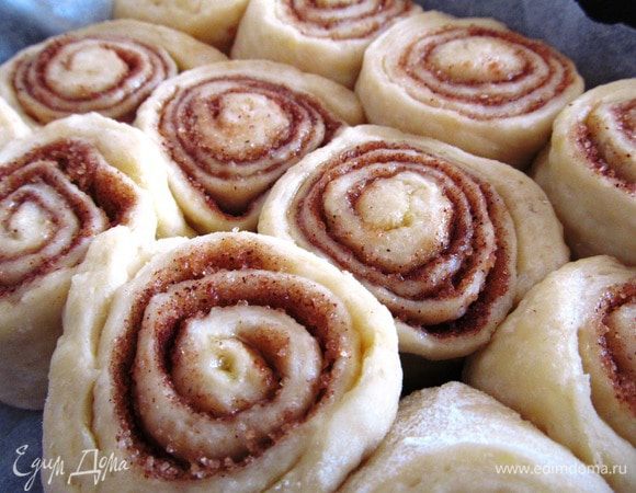 Духовку разогреваем до 180 градусов. Тесто раскатываем примерно 30 на 40 см. Толщина должна быть около 5 мм. Смазываем тесто сливочным маслом. Сахар перемешиваем с корицей и вкладываем на смазанное маслом тесто. ВНИМАНИЕ, обязательно нужно с одной стороны оставить около 3 см, чтобы булочки склеились в конце, и был красивый шов. 
Заворачиваем тесто в рулет. ВНИМАНИЕ, в настоящих Синнабон должно быть не более 5 витков. ВАЖНО закрутить рулет ПЛОТНО. Вы же не хотите получить бабушкины лепешки?! 
Разрезаем ножом булочки (примерно 3 см) и выкладываем в форму на расстоянии 3 см. Накрываем полотенцем и отправляем в теплое место минут на 15. Выпекаем 15-25 минут в зависимости от Вашей духовки. Проверить готовность можно шпажкой. 
