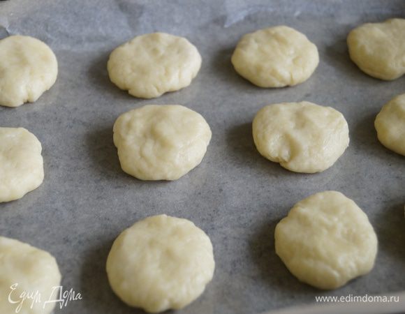 От теста отделить небольшой кусочек, и сформировать из него шарик, приплюснуть. Выложить на противень застеленный бумагой для выпечки.