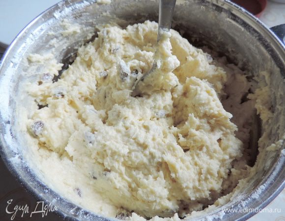 Теперь просеиваем сверху всю муку с разрыхлителем (разрыхлитель должен быть рассчитан на 500 г муки). Сверху на муку высыпаем промытый и обсушенный изюм. Теперь все спокойно перемешиваем ложкой или лопаткой до однородного состояния. Получаем довольно густое и вязкое тесто.