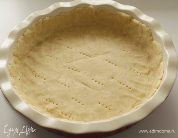 Затем распределить тесто в форме 25 см, сделать проколы вилкой, поставить выпекаться с грузом мин на 10.