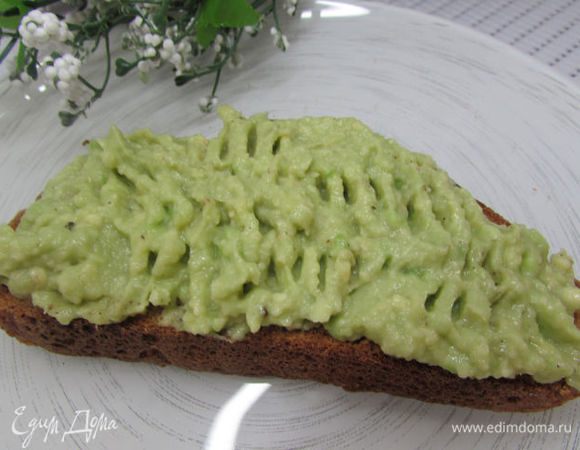 Смажьте кусочки поджаренного хлеба пюре из авокадо.