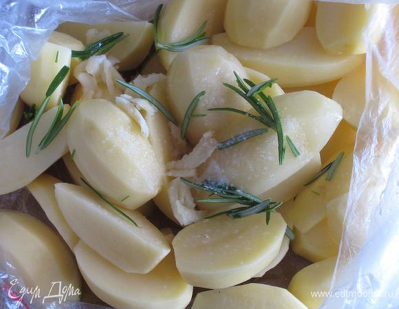Чеснок мелко порубить.Картофель нарезать дольками,положить в полиэтиленовый пакет,добавить соль,розмарин,оливковое масло, сок 1 лимона , чеснок и хорошо встряхнуть пакет .
