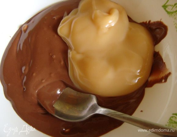 Далее делаем нугу. Молочный шоколад растопить. Я делаю в микроволновке, так быстрее и проще, около двух минут. Добавить вареную сгущенку и размягченное сливочное масло, перемешать.