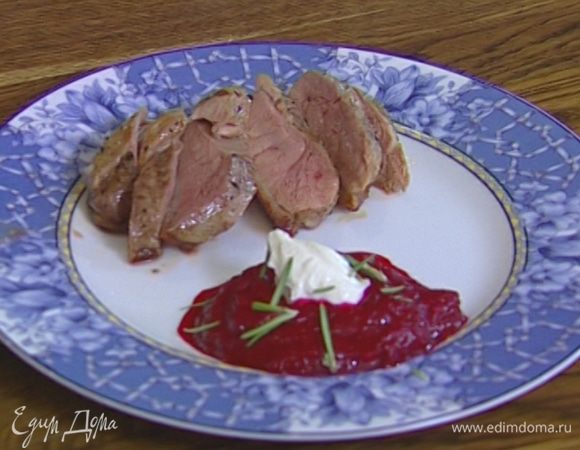 Рядом с утиным мясом выложить свекольное пюре, украсить его сметаной и присыпать листьями розмарина.