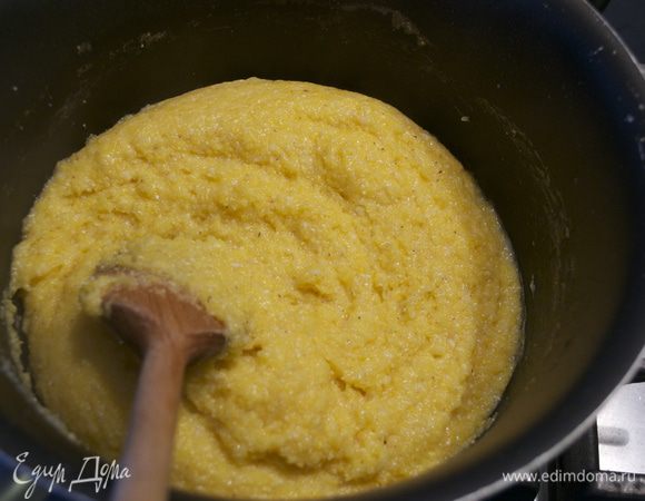 Нагреть духовку до 200 С. Оставшуюся воду (0,5 л) вылить в кастрюлю, взболтать в ней кукурузную крупу и, помешивая, довести до кипения. Добавить соль и сыр. Уменьшить огонь и варить еще минут 15, помешивая. 