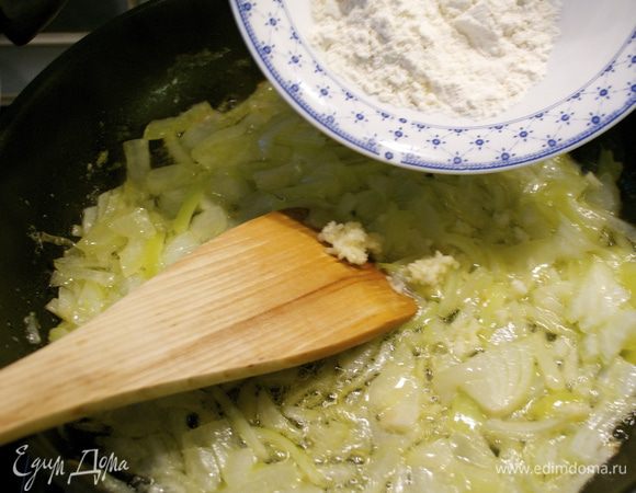 Добавить к луку муку и измельченный чеснок. Подержать 1 минуту на огне.