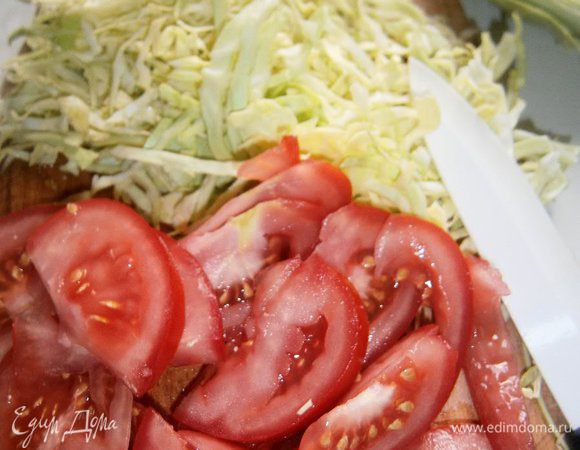 Молодую зелёную капусту нашинковать. Помидор нарезать тонкими ломтиками. Зелень тархуна мелко нарезать.