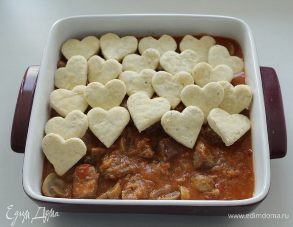 И перенести сконы на выложенное, в форму для запекания, мясо с грибами.