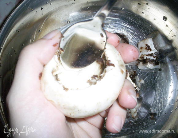 Шампиньоны лучше выбирать покрупнее. У меня 6 штук весили аж полкило))) Первым делом моем грибы. 
Удалить ножки и часть мякоти из шапочки. Это удобно сделать с помощью чайной ложечки.