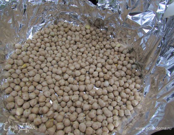 Достаньте тесто из холодильника, накройте его фольгой или пергаментом и сверху выложите фасоль (у меня нут). Поставьте в разогретую духовку (180 градусов) на 15 минут.