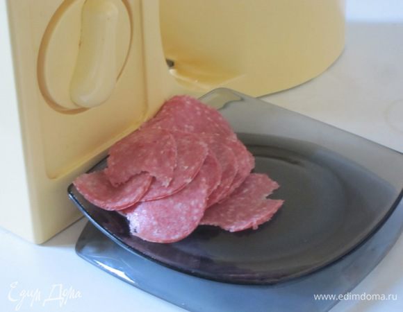 Копченую колбасу тонко нарезать электрической ломтерезкой.