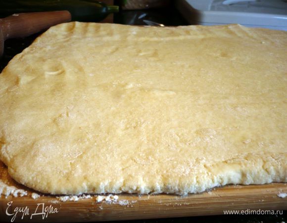 Выложим тесто на хорошо присыпанную мукой поверхность, тесто присыпем сверху также мукой и раскатаем в прямоугольный пласт примерно 35 на 25 см.