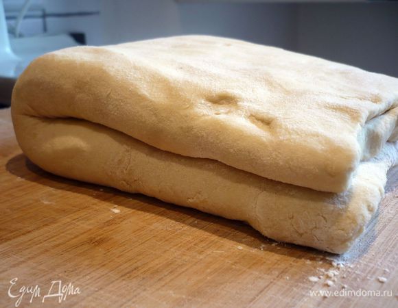 Теперь сворачиваем полученный пласт пополам. Заворачиваем тесто в пленку и убираем в морозилку на 16 — 18 минут. Достаем тесто из морозилки, раскатываем его на присыпанной мукой поверхности и повторяем ту же самую процедуру сворачивания, так называемый одинарный тур. Сворачиваем сложенное тесто пополам. Заворачиваем в пленку и убираем в морозилку снова на 16 — 18 минут.